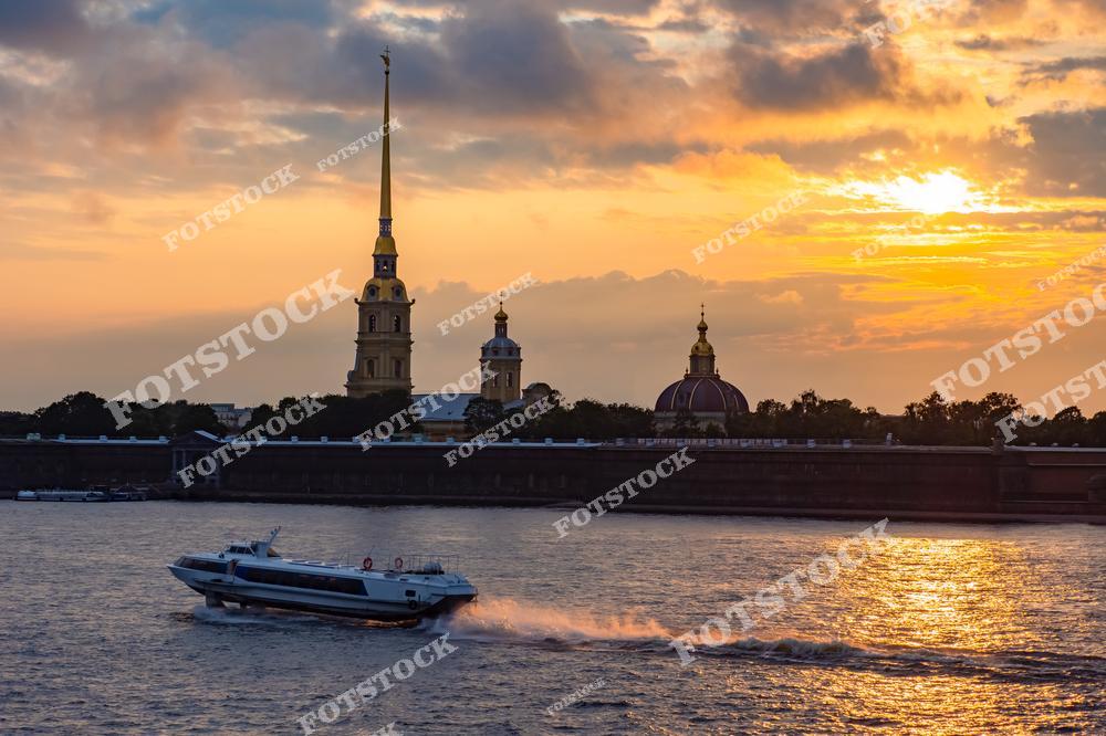Фотография атмосферного городского пейзажа в Санкт-Петербурге, Россия, сделанная в период белых ночей. На изображении показана Петропавловская крепость, расположенная на берегу реки Нева. Фотоснимок передаёт особое настроение северного города, когда ночь почти не отличается от дня, а мягкий свет окутывает архитектуру и воду. На фото виден прогулочный катер, плывущий по реке, что подчёркивает туристическую привлекательность Санкт-Петербурга в сезон белых ночей. Это изображение отражает концепцию городов России и уникальный опыт посещения Петербурга летом. Иллюстрация может использоваться как картинка или слайд, посвящённые рекам и романтической атмосфере города.